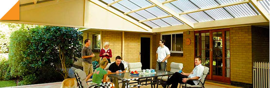 family eating at a table below a pergola